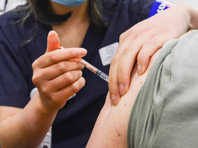 ADELAIDE, AUSTRALIA - NewsWire Photos NOVEMBER 4, 2021: SA Health vaccinator Xuan gives paramedic Sharon Hennessy a Covid booster vaccine at Wayville Vaccination Clinic. Picture: NCA NewsWire/Brenton Edwards