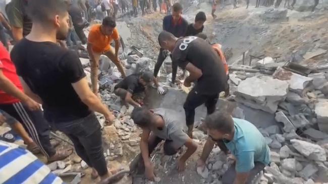 Palestinians looking for survivors in a crater following a stike on a refugee camp in Jabalia on the northern Gaza Strip on Tuesday. Picture: AFP