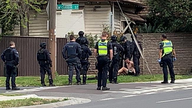 Officers detain the man on the ground.