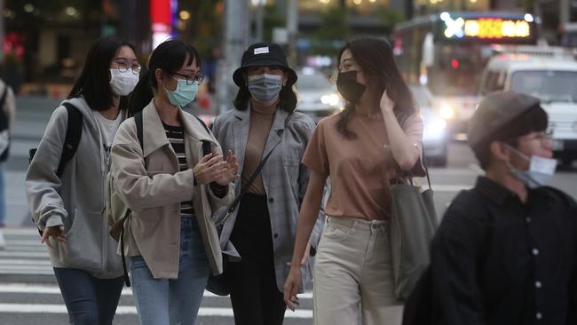 Pedestrians wear face masks to protect against the spread of COVID-19 on the streets of Taipei this week. Picture: AP