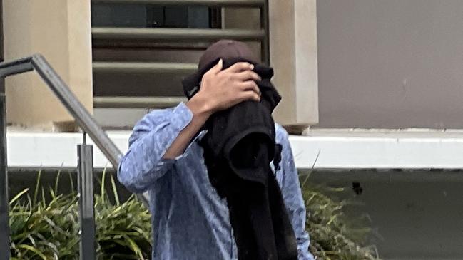 Leslie Campbell shielded his face with his jacket as he left Wollongong Courthouse. Picture: Dylan Arvela