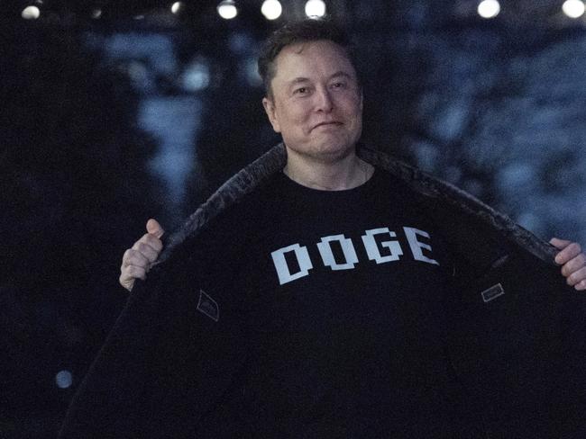 Elon Musk flashes his T-shirt that reads 