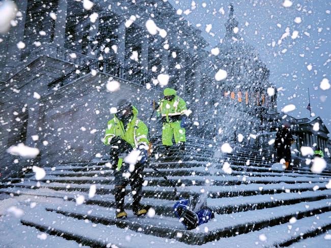 Crews work before dawn to clear snow from the steps on the East Front of the U.S. Capitol as a winter storm slams into the nation's capital. Picture: Getty Images via AFP