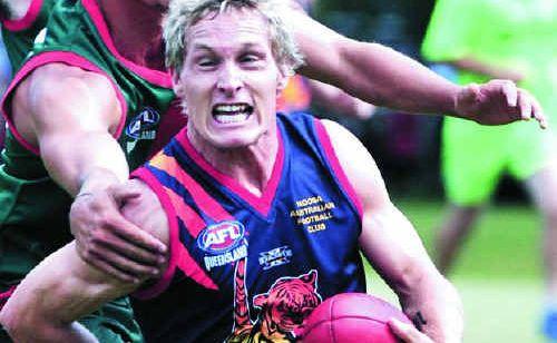 Noosa’s Travis Mills battles to elude a Sandgate opponent at a post-flood fundraiser on March 26. Picture: GEOFF POTTER