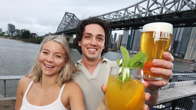 Kira Eagles and Lucas Eckersley share a drink under the Story Bridge at Howard Smith Wharves. The site is getting a makeover. Picture: Liam Kidston