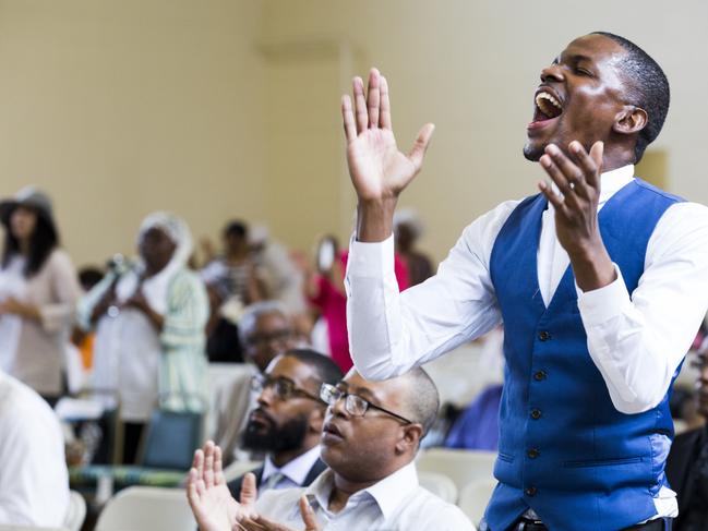 Joshua Mills sings and claps along to the band at The First Church of Our Lord Jesus Christ. Picture: Rachel Wisniewski