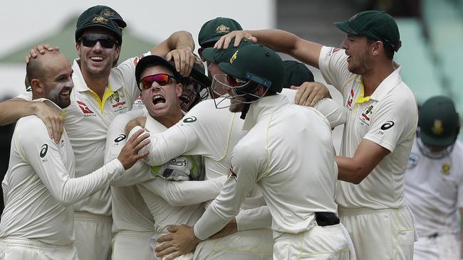 Nathan Lyon (L) and David Warner (C) celebrate after running out South Africa's AB de Villiers.