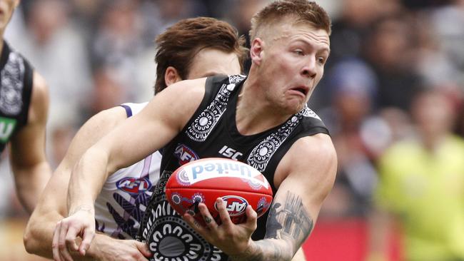 Jordan De Goey of the Magpies handpasses the ball whilst being tackled during the Round 11 AFL match between the Collingwood Magpies and the Fremantle Dockers at the MCG in Melbourne, Saturday, June 1, 2019. (AAP Image/Daniel Pockett) NO ARCHIVING, EDITORIAL USE ONLY