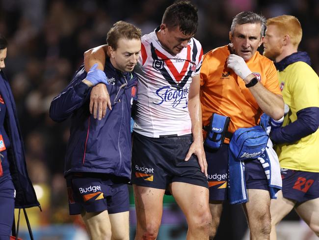 PENRITH, AUSTRALIA - MAY 12:  Joseph Manu of the Roosters is assisted off the field after an ankle injury during the round 11 NRL match between the Penrith Panthers and Sydney Roosters at BlueBet Stadium on May 12, 2023 in Penrith, Australia. (Photo by Mark Kolbe/Getty Images)