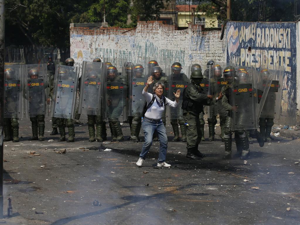 A demonstrator tries to stop the violence as she stands in front of a line of Bolivarian National Guard officers during clashes in Venezuela. Picture: AP Photo/Fernando Llano