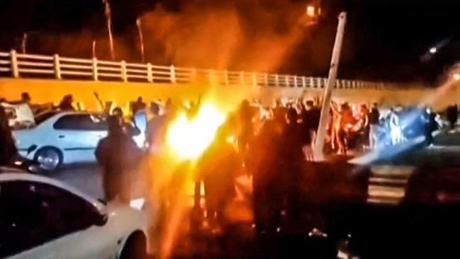 Iranian protesters gather late on Saturday on a road leading to Tehran’s Evin prison, where authorities say eight people were killed in a fire. Picture: AFP