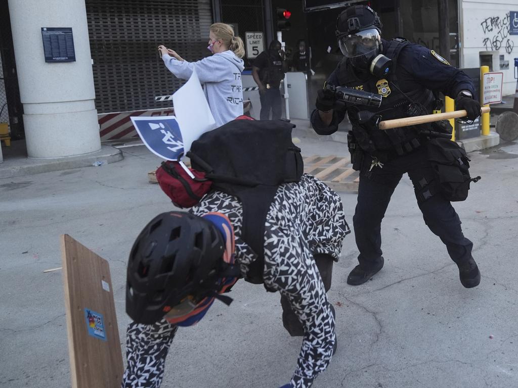 A protester attempts to evade a Department of Homeland Security officer after federal immigration authorities conducted an operation. Picture: AP