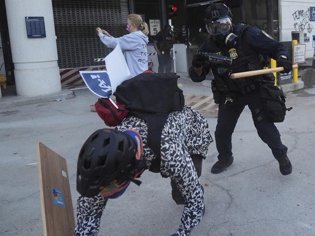 A protester attempts to evade a Department of Homeland Security officer after federal immigration authorities conducted an operation. Picture: AP