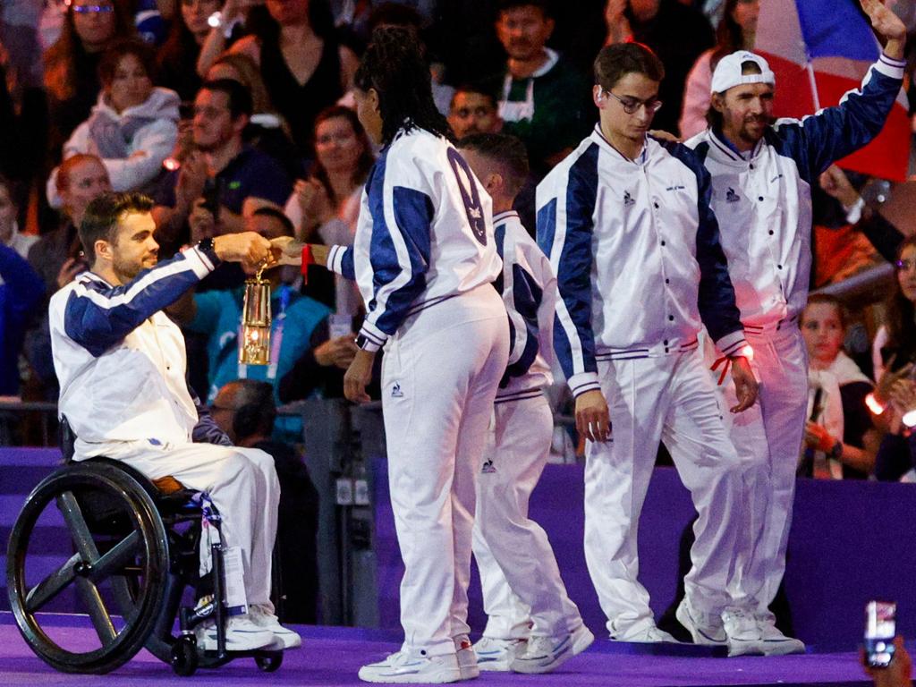 France’s Gloria Agblemagnon, second left, hands the Olympic flame to Mathieu Bosredon, far left, next to Ugo Didier and Frederic Villeroux during the closing ceremony at the Stade de France. Picture: Geoffroy Van Der Hasselt/AFP