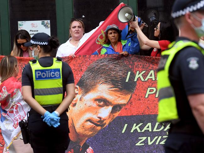 Djokovic supporters unfurl a banner bearing his face on Friday. Picture: William West / AFP