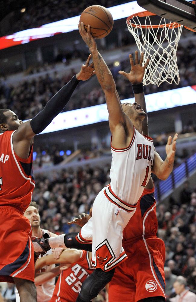 Chicago Bulls' Derrick Rose goes up for a shot against Atlanta Hawks' Paul Millsap and Jeff Teauge.