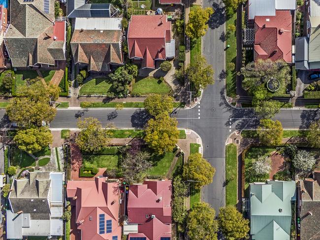 Aerial view of leafy eastern suburban houses on 4-way cross road intersection in Adelaide, South Australia: directly above, rooftop solar, trees. Housing property generic