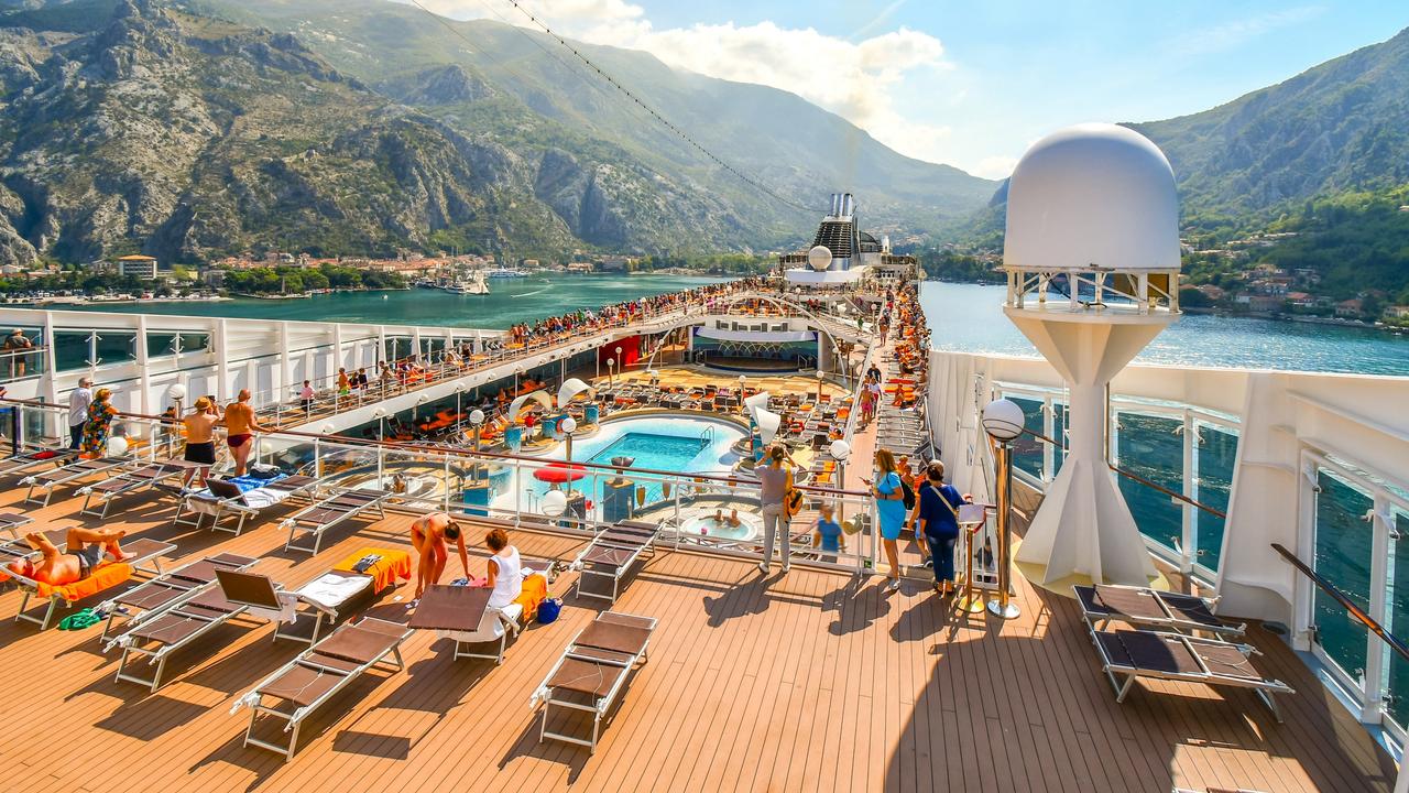 Crowded upper deck of the MSC Musica cruise ship as it pulls into the harbour of Kotor Montenegro on Boka or Bay of Kotor. Escape 4 August 2024 Doc Holiday Photo – iStock