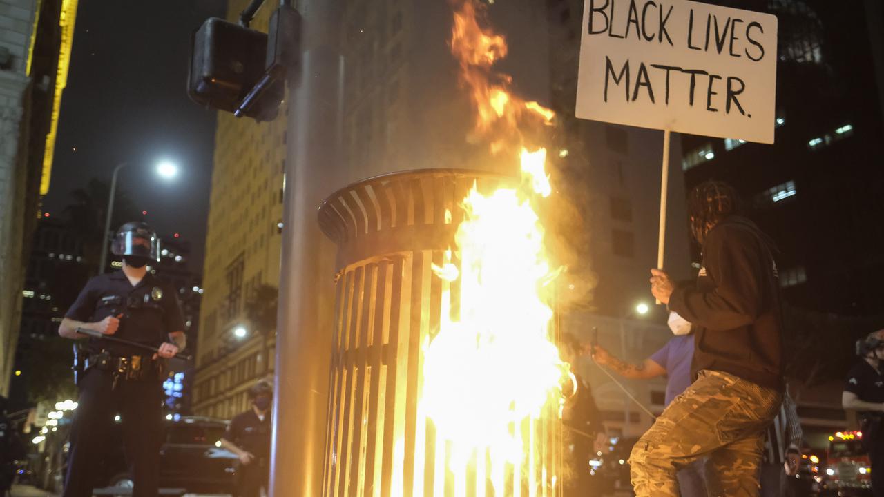 A garbage bin burns between a police officer and a protester. Picture: Ringo H.W. Chiu/AP