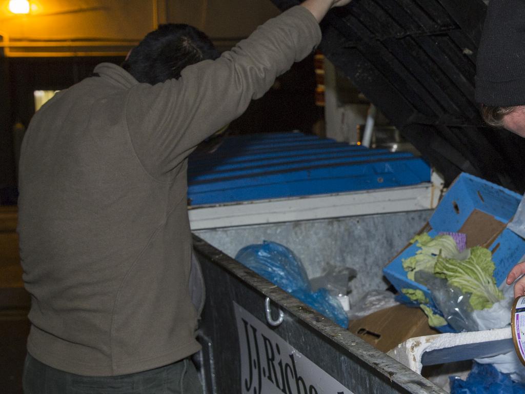 Locals in Sydney, battling with the rising costs of living, are forced to look through bins in search for food