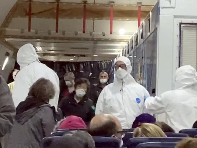 US passengers off the quarantined cruise ship the Diamond Princess and officials wait for the plane to take off for America. Picture: AP