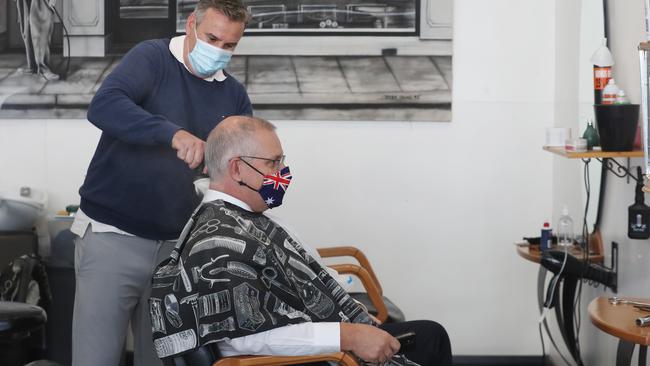 Scott Morrison gets a haircut at a barber shop in Malvern, eastern Melbourne, on Tuesday. Picture: David Crosling