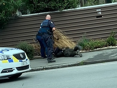 Tarrant is pushed face-first on to the footpath. Picture: Supplied