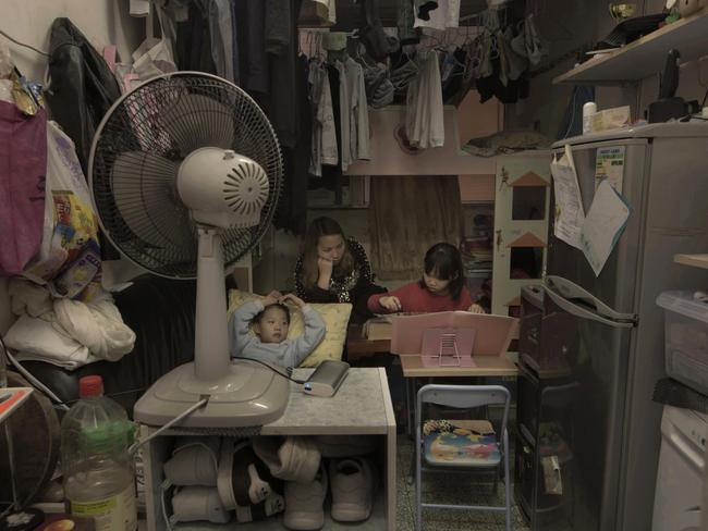 Li Suet-wen and her son, 6, and daughter, 8, live in a 11-square metre room crammed with a bunk bed, small couch, fridge, washing machine and small table in an ageing walk-up in Hong Kong as she pays$785 a month in rent and utilities. Picture: Kin Cheung/AP