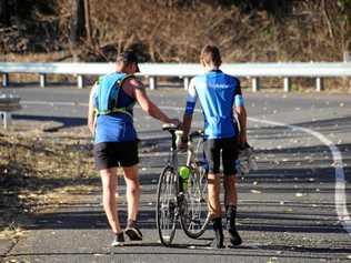 TRUE SPORTSMANSHIP: Runner Lee Pratt stops to help a cyclist finish Challenge the Mountain. Picture: Rockhampton Photography Club