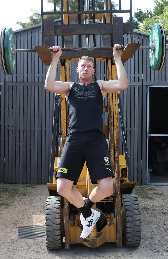 Grimes uses the barbell to do pull-ups as he works to maintain his strength during the enforced lay-off.