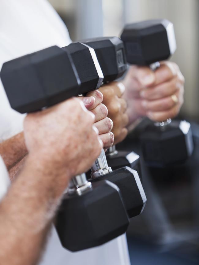 Gym-goers lifting weights at the gym.