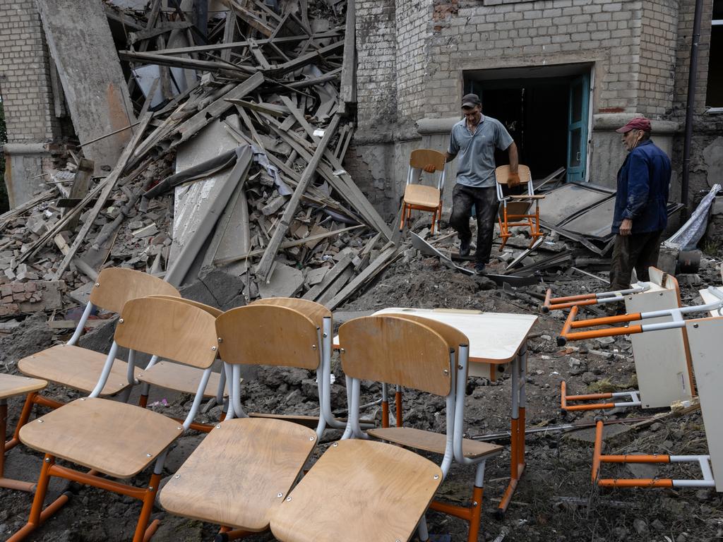 Workers carry school desks out from classrooms after the overnight rocket attack in Kostyantynivka, Donetsk District, Ukraine. Picture: Paula Bronstein/Getty Images