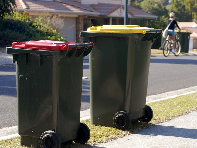 Two rubbish bins in Australia. Red lid is rubbish, yellow lid is recycling.