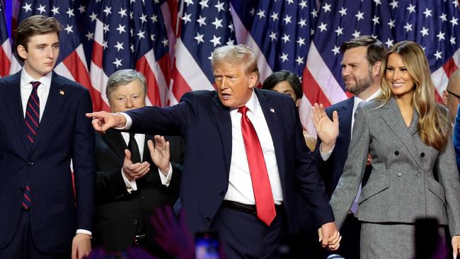 Donald Trump points to supporters with former first lady Melania Trump during an election night event at the Palm Beach Convention Center. Picture: AFP