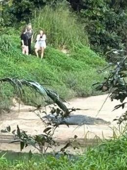 Three young women spotted getting close and personal with a saltwater crocodile, known by Babinda residents as Clyde.