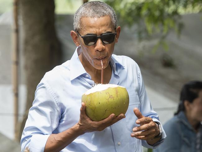 US President Barack Obama drinks from a coconut as he makes a surprise stop for a drink alonside the Mekong River in Luang Prabang on September 7, 2016. Picture: AFP PHOTO / SAUL LOEB