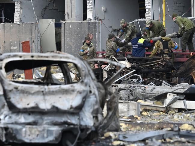 Ukrainian servicemen load a fragment of a rocket onto a truck outside a building in Kyiv. Picture: AFP