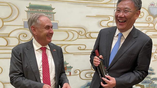 Trade Minister Don Farrell gives Chinese Commerce Minister Wang Wentao a bottle of his ‘Godfather Too’ shiraz after their high-level talks on Friday night.