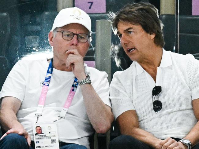 US actor Tom Cruise (R) speaks with Warner Bros CEO David Zaslav (L) as they attend the artistic gymnastics women's qualification during the Paris 2024 Olympic Games at the Bercy Arena in Paris, on July 28, 2024. (Photo by Loic VENANCE / AFP)