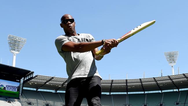 Jamaican sprint star Asafa Powell tries his hand with a cricket bat during a visit to the MCG yesterday ahead of tonight’s Nitro Athletics meeting. Picture: Nicole Garmston