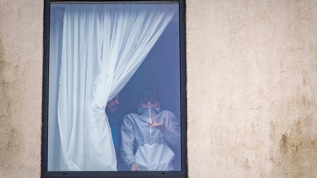 A man believed to be a a resident at the Holiday Inn Express Hotel, which houses asylum-seekers, gestures as anti-migration protesters attack the hotel in Rotherham on Sunday. Picture: Getty Images