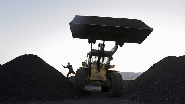 A driver jumps off a loading vehicle at a coal depot on the outskirts of Jixi, in Heilongjiang province, China, Oct. 23, 2015. PHOTO: JASON LEE/REUTERS