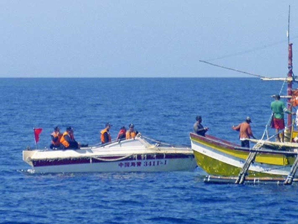 Chinese Coast Guard members approach Filipino fishermen near Scarborough Shoal in the South China Sea. An international tribunal has found that there is no legal basis for China's claiming rights to much of the South China Sea. Picture: AP