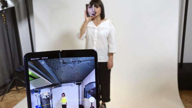 A model holds a Samsung Galaxy Fold smart phone to her face, during a media preview event in London. Picture: AP Photo/Kelvin Chan