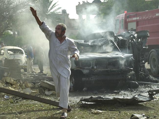 ‘Deadly, effective and ruthless’ … an Iraqi man rushes to the scene of the suicide car bombing outside Minister al-Sheikhli’s home.