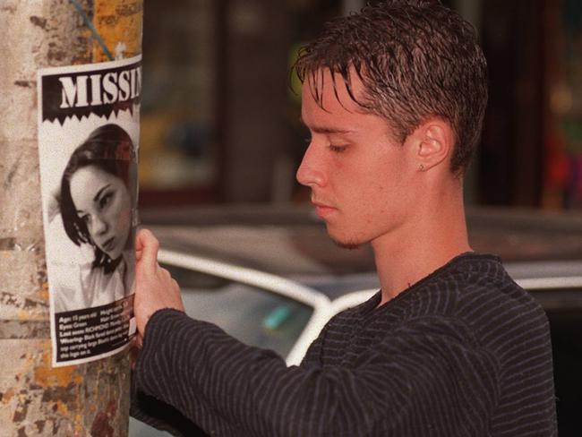 Manny Carella sticks a poster of his missing girlfriend to a street pole in Richmond.