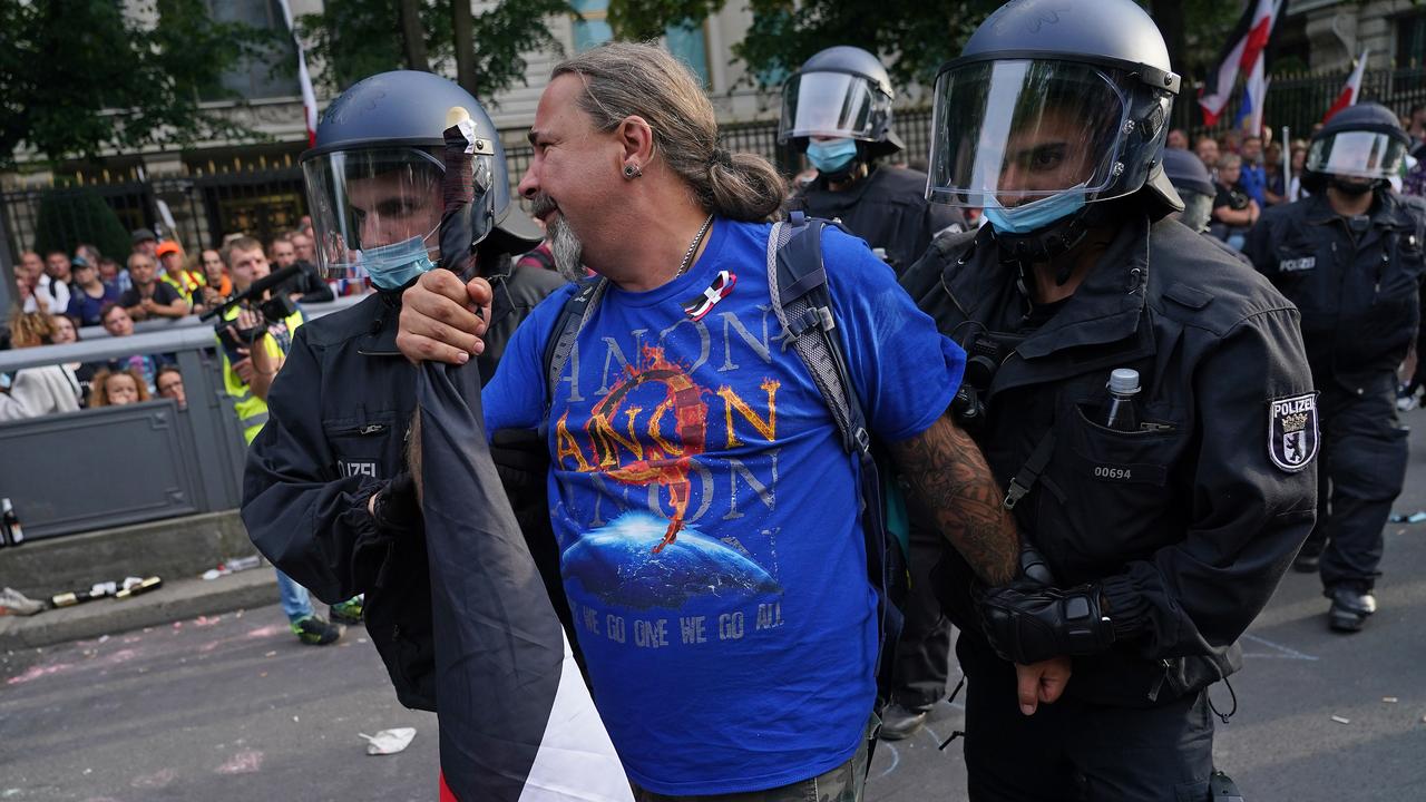 Riot police detain a man wearing a QAnon shirt during protests against coronavirus-related restrictions and government policy. Picture: Sean Gallup/Getty Images