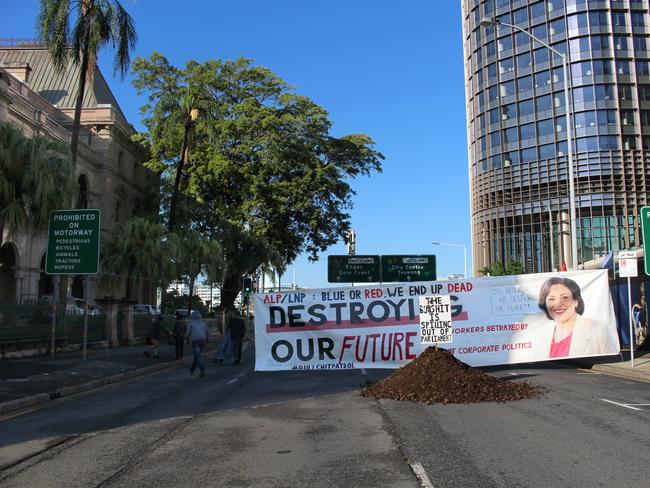 A banner featuring a picture of Jackie Trad was placed near a pile of manure dropped outside Parliament House by Extinction Rebellion activists. Picture: Nathan Edwards