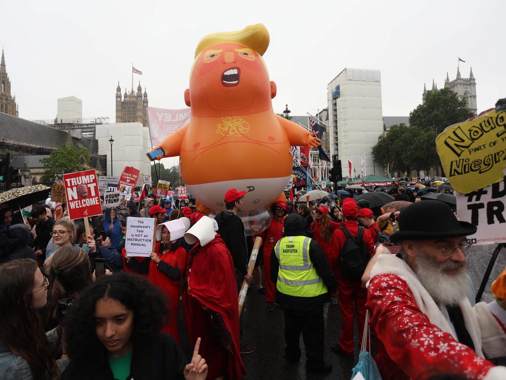 A giant balloon depicting Mr Trump as an orange baby floated above Parliament Square as the President passed in his motorcade. Picture: Isabel Infantes / AFP