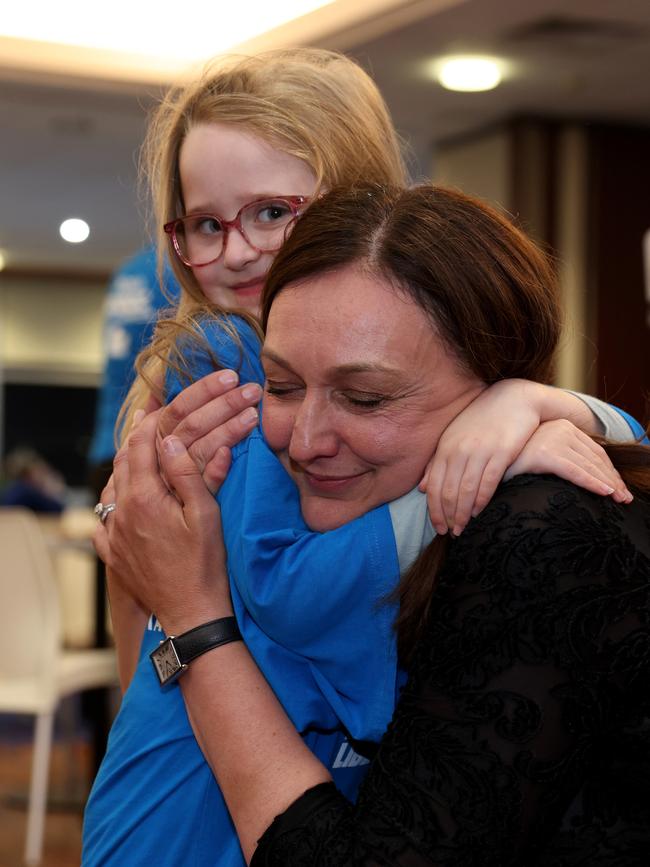 Liberal candidate Maria Kovacic embraces six-year-old volunteer Alira Walker as she enters Rydalmere FC. Picture: Damian Shaw